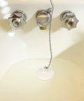 Heavy Hitter 2 Pack Rubber Tub Stopper With Smooth Pull Chain Fits 1 To 1 3 8 Inch Drains in a bathtub with chain attachment.
