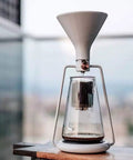 Elevate Your Daily Grind With This Dope 3-In-1 Coffee Kettle, Cold Brew And Ice Drip Maker, Manual Filter Teapot For Smooth Lattes And Cappuccinos, Matte Black Finish, glass kettle with white funnel top.