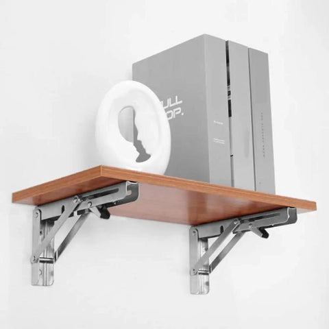 Heavy Duty Stainless Steel Shelf Brackets 2 Pack Bright Silver Folding Wall Mounts holding a wooden shelf with decorative items.
