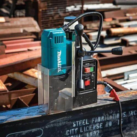 Makita HB350 1-3/8-inch magnetic drill on steel beam; teal housing with cord visible.