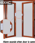 Installed personal security window and door alarm bell wireless sensor system pack of 10 showing adhesive mount on wooden door.