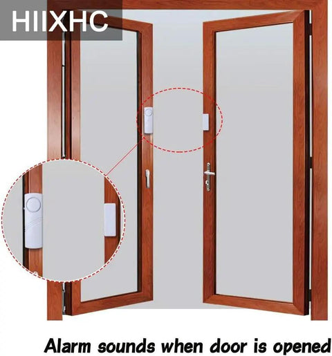Installed personal security window and door alarm bell wireless sensor system pack of 10 showing adhesive mount on wooden door.