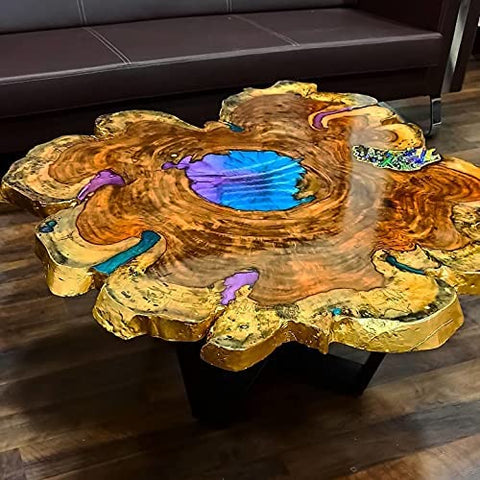 Wooden river table with vibrant resin inlay on a polished slab, showcasing natural wood grain and blue resin accents in a living room.