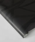 Geometric Metallic Black Intersections Peel and Stick Wallpaper by Genevieve Gorder roll, close-up view showing pattern and texture.