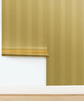 Hella Glam Farmhouse Stripe Gold Metallic Wallpaper With Textured Fibrous Grain Easy Glide Paste The Wall Covering Usa Crafted Eco Clean Next Level Shine Strips For Cozy American Homes Today displayed on wall with rolled section.
