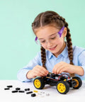 Girl using Six Crew Pack Youth Safety Glasses With Anti Fog And Uv400 Tint, assembling a toy car with small parts.