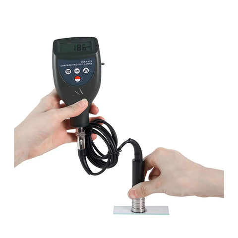 Pro Grade Digital Roughness Tester And Surface Profile Gauge With Separate Cabled Probe For Blast Cleaned Surfaces, 0-800 Micrometers And 0-29.5 Mils Range, Tungsten Carbide Tip Lasts 20k Readings, Rugged On The Go in use with hands holding device and probe.