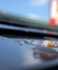 Close-up of Heavy Duty Tough As Nails Clear Roof Sealer Stops Leaks Cold with water droplets on metal surface.