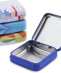 ZEISS lens-cleaning tin boxes with hinge lids, set of 4; blue opened tin in foreground, colorful tins stacked behind.