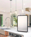 Titanium cutting board with black edge, front view on a white kitchen island.