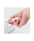 Hand holding easy grab handle of stackable plastic food storage bin for kitchen pantry cabinet refrigerator and freezer
