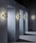 Awsinil Fluted Glass Wall Sconce, Modern Iron Round Decorative Wall Light mounted on grey wall, illuminating textured shadows.