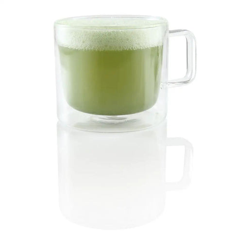 Glass mug with green matcha latte foam, demonstrating Milk Café Frother With Induction Heating Delivers Rich Creamy Foam For Lattes And Cappuccinos.