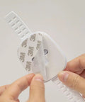 Close-up of a hand peeling adhesive on an Upgraded No Drill Furniture Wall Anchor For Baby Proofing And Child Safety, white strap lock.