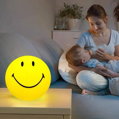 Smiley Face Night Light For Kids USB Rechargeable Portable Nursery Lamp with warm glow next to mom holding baby at night