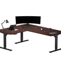 Slick Electric L Shaped Corner Standing Desk 60 By 72 Inches with rich dark cherry laminate top and modern black frame.