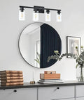 Industrial Indoor Four Light Bathroom Vanity Light In Black With Clear Glass Shades above a round mirror on white wall