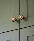 Close-up of 6 Pack Antique Brass Zinc Alloy Cabinet Knobs And Drawer Pulls For Kitchen Cabinets on olive green doors.