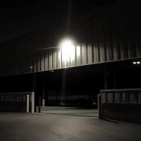 Dusk To Dawn LED Security Light With Built In Sensor 18W Plug In Flood Light Outdoor 5000K Daylight 1600LM lighting a garage.