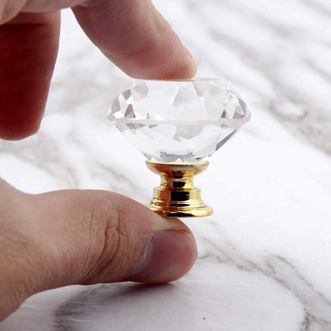 Hand holding 8 Pack Crystal Glass Cabinet Knobs with Gold Base, diamond style, for kitchen cabinets or dressers, 1.2 inch diameter.