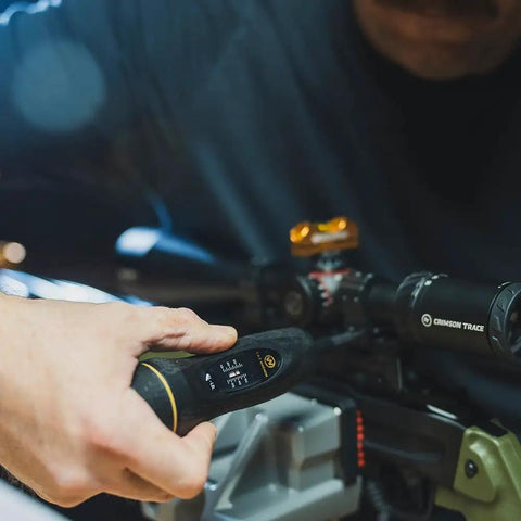 Hands using All In One Scope Mounting Kit With Laser Bore Sighter, Reticle Leveling System, and Fat Wrench on rifle scope.