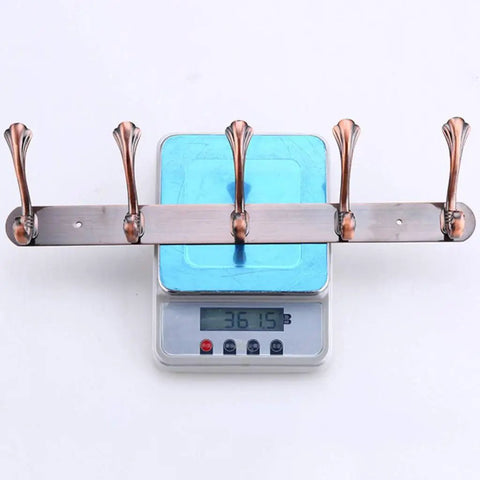 Heavy Duty Stainless Steel Wall Coat Rack With Five Sturdy Hooks For Coats Hats Robes And Towels showing weight on scale.
