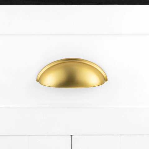 Brushed Gold Cup Drawer Pulls 3 Inch 76mm Set of 10 Durable Metal Cabinet Handles mounted on white drawer front.