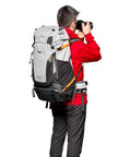 PhotoSport Pro 55L Camera Backpack With Front And Rear Access For DSLR And Mirrorless, worn by photographer in red jacket