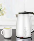 Heavy Duty 304 Stainless Steel Electric Kettle 1.7 Liter 1830 Watt Kicking Boils Fast next to a white cup of tea.