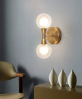 Rock This Mini Two Light Gold Bathroom Vanity Wall Sconce With Clear Glass Shades Mid Century Modern Style lit on wall