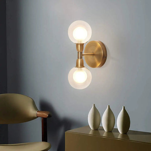 Rock This Mini Two Light Gold Bathroom Vanity Wall Sconce With Clear Glass Shades Mid Century Modern Style lit on wall