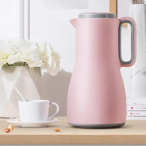 Grab And Go Kickass Vacuum Insulated Travel Thermos With Secure Silicone Lid Locks In Scalding Heat Or Ice Cold Temperatures All Day Long Killer For Daily Commutes pink stainless steel thermos on wooden table with coffee cup and flowers