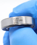 Close-up of Sealed Cartridge Bearing Set 18 X 30 X 7 mm MR18307 RS 5 Pack for Bike Hubs with visible engraving, held in blue glove