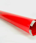 Red diamond core drill bit, side view; cylindrical body with segmented diamond cutting edge at end.