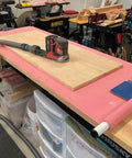 Quick Click 16 Foot Commercial Vacuum Hose with sander on workbench for dust collection in workshop