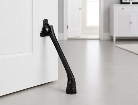 Heavy Duty Kickdown Door Stopper With Extended Reach Design And Rock Solid Zinc Alloy Frame For Tight Grip Non Slip Rubber Foot mounted on a white door.