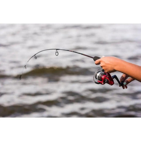 Angler holding Dock Runner Spinning Reel And Fishing Rod Combo 36 Inch Medium Action Multi Piece Rod Setup with lake background