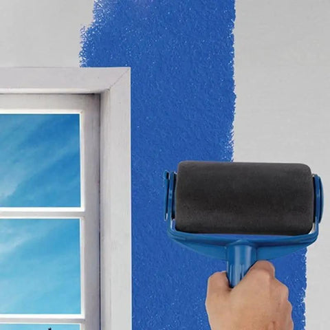 Hand holding a blue paint roller applying paint to a wall, showing the Total Game Changer Eight Piece Paint Roller Corner Brush Kit.