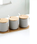 Top Shelf Ceramic Coffee Storage Jar With Secure Wooden Lid And Airtight Design Keeps Daily Grind Sugar Salt Tea Fresh As Ever While Looking Slick On Any Modern Counter Space, set of three jars on bamboo tray.