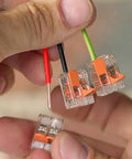Hands holding Lever Nut Wire Connector Set 221 Series 35pc Compact Splicing Kit with transparent blocks and copper wires.