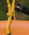 Heavy Duty Rubber Blanket Clamp Pin Pack Of 12 With Yellow Nylon Elastomeric Tips Fiberglass Body Rugged Spring Clip Rubberized Tips Will Not Scratch Blankets Made In USA gripping an orange surface outdoors