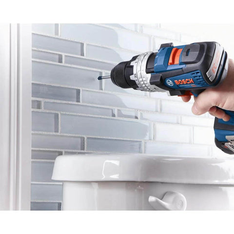 Bosch blue cordless drill side view with attached bit near a tiled wall.