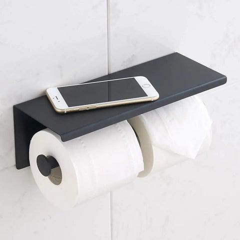 Stainless Steel Double Toilet Paper Holder With Shelf Wall Mounted Matte Black Finish displaying two rolls and a phone.