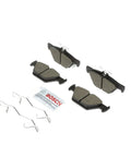 Bosch BC1808 QuietCast ceramic rear brake pads set, top-down view with retaining springs and lubricant packet.