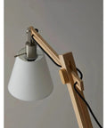 Close-up of Walden Floor Lamp With Natural Wood Body On Satin Steel Base, Off White Poly Cotton Bell Shade, adjustable height feature.