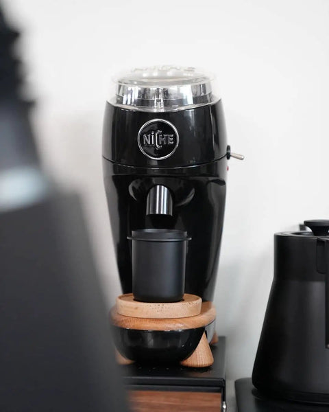 58mm Espresso Dosing Cup For Single Doses with a black coffee grinder, showcased in a home barista setup, Nonstick 304 Stainless Steel.