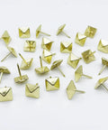 Real Deal Golden Square Upholstery Tacks Heavy Duty Shanks For Couch And Woodwork Revival 200 Pc Vintage Decorative Nail Kit laid out on white background.