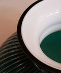 Close-up of 10 Inch Ribbed Student Lamp Shade In Cased Green Over Opal Design For Vintage And Antique Lighting, showing polished edge.
