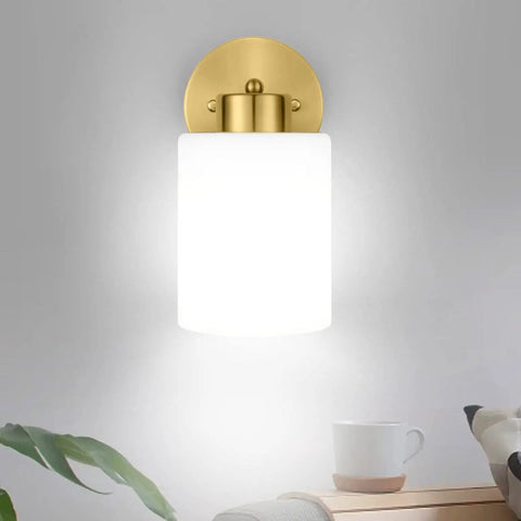 Frosted Wall Sconce Set Of Two In Brushed Gold Modern Sleek Brass Vanity Lights For Bathroom Living Room And Kitchen Mid Century Style Two Pack Frosted Shade Wall Lamps with glowing frosted glass shade against gray wall.