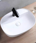 Top view of USZWBY Vessel Sinks Minimalist Ceramic Table Basin with black faucet, ideal for modern bathrooms.